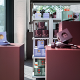 Retail packaging for AVOLT Square range — stacked boxed power outlets and cables on display shelves in a shop